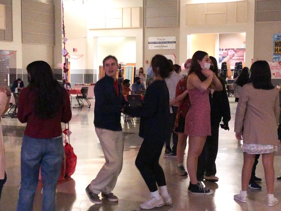 Susan Barner ‘23 and her buddy John Lewis hold hands as they dance to a well-known pop song. The pair enjoyed dancing and socializing with the other attendees throughout the night. 