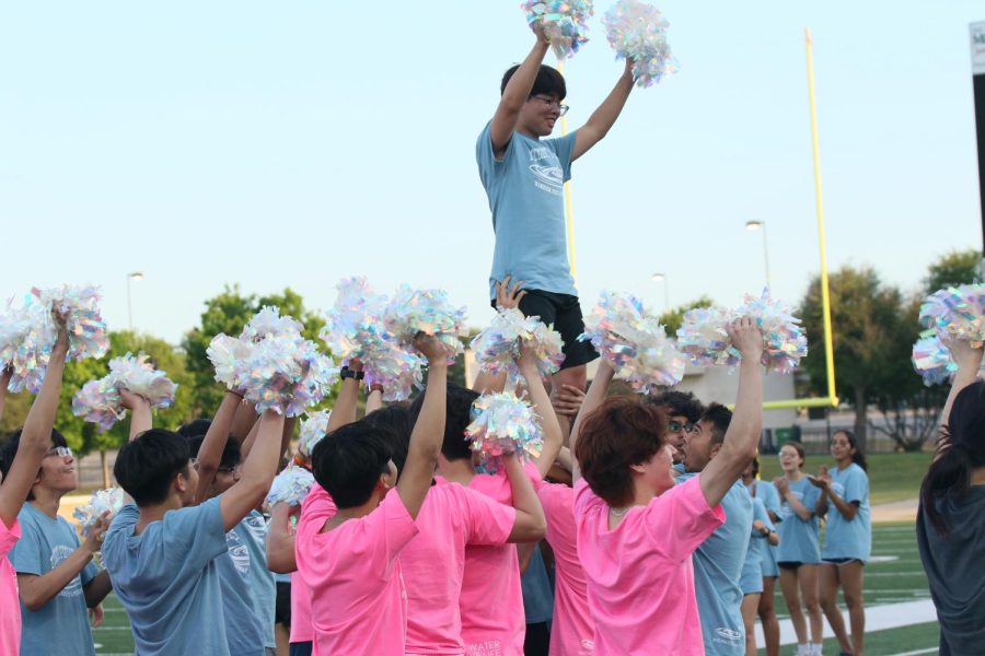 While performing a cheer routine, Eric Gao ‘22 shows his school spirit while being lifted into the air. The male cheerleaders performed many different cheer chants throughout the game.