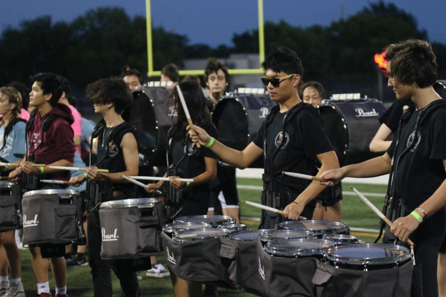 Standing on the sidelines, Joshua Lee 22 performs a set with the rest of the drumline. The members of the drumline were able to successfully engage the audience sitting in the bleachers. 
