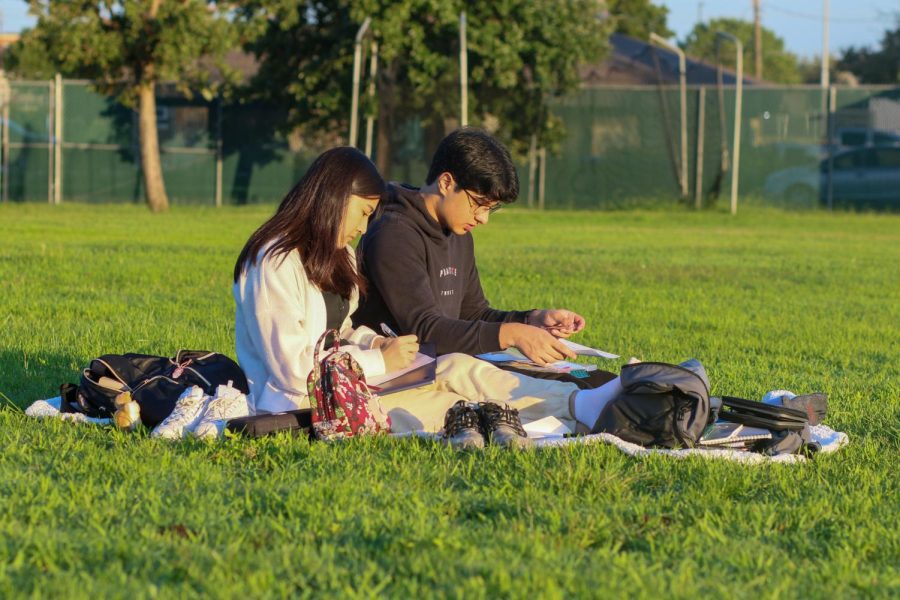 Seniors Annette Ho and Akhil Gharpurey concentrate on write letters to their future selves while watching the sunrise.