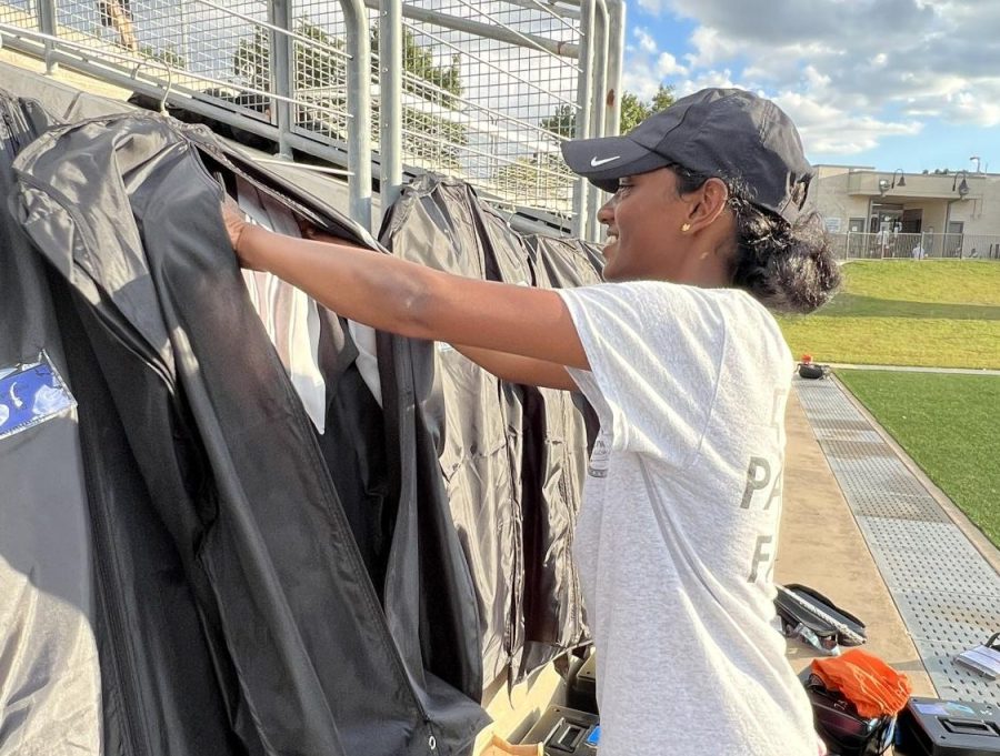 Reaching for her uniform, Tharini Murugananth ‘25 gets ready to change for the show. The uniform consists of multiple parts, including specific shoes and gloves.