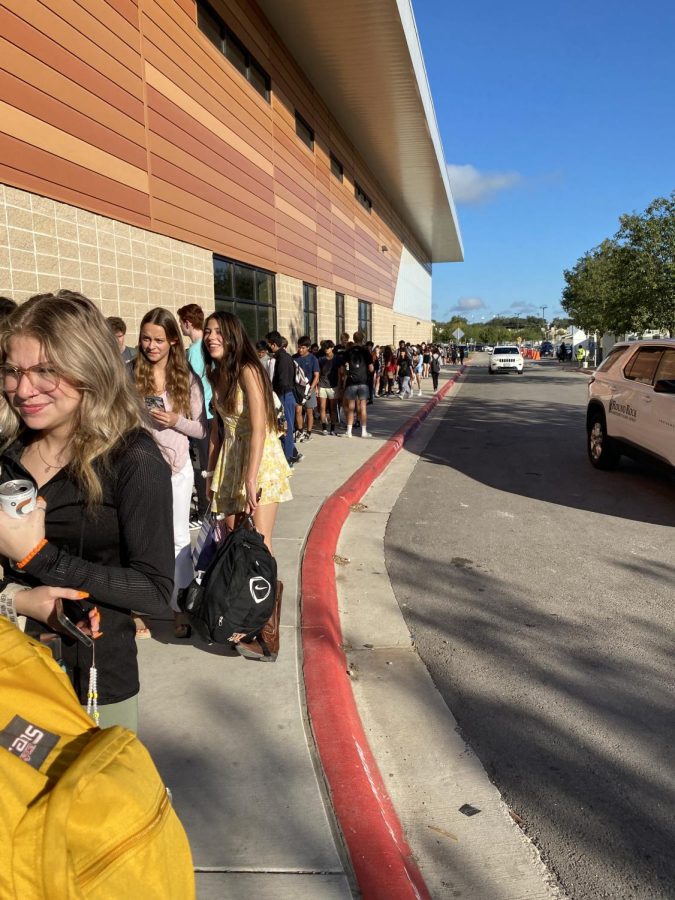 Students wait in line to have their bags checked before entering the school on Sept. 20.