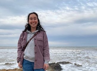 Smiling, Ms. Brissa Ochoa poses for a photo on a beach. While in Spain for the past four years, Ms. Ochoa taught English Language Arts at an American school.