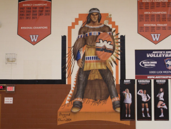 A portrait of an Indigenous person is painted in the field house gym. The school mascot is intertwined with Westwood sports traditions. 