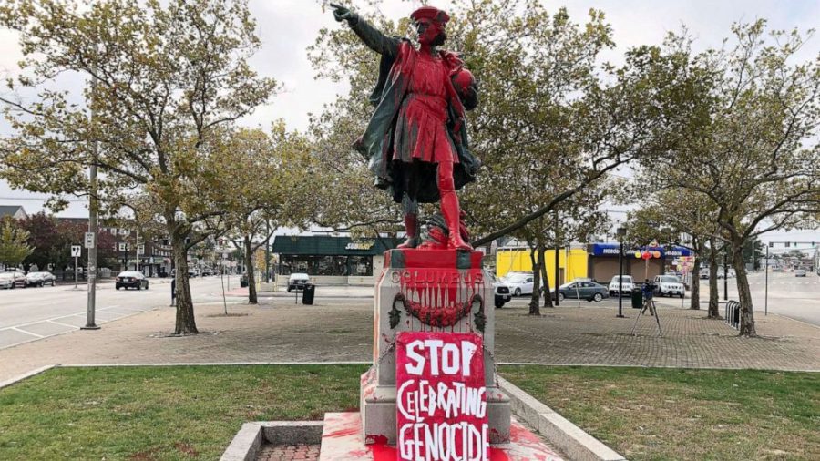 A+defaced+statue+of+Christopher+Columbus+splashed+with+red+paint+and+a+sign+placed+at+the+foot+that+reads+stop+celebrating+genocide+in+Rhode+Island.+The+statue+was+vandalized+on+Columbus+Day+in+2019.+Columbus+Day++has+been+the+subject+of+controversy+for+decades+since+it+was+made+a+federal+holiday+in+1937+by+Franklin+D.+Roosevelt.
