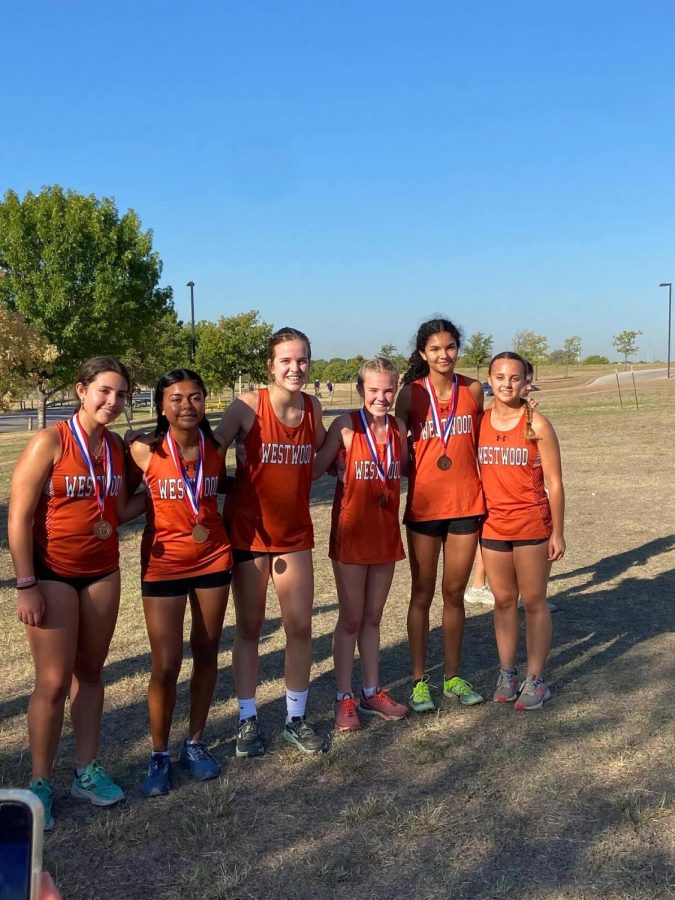 The varsity girls team celebrates their second place ranking. This meet marked the most medalists the team has had this season. 
