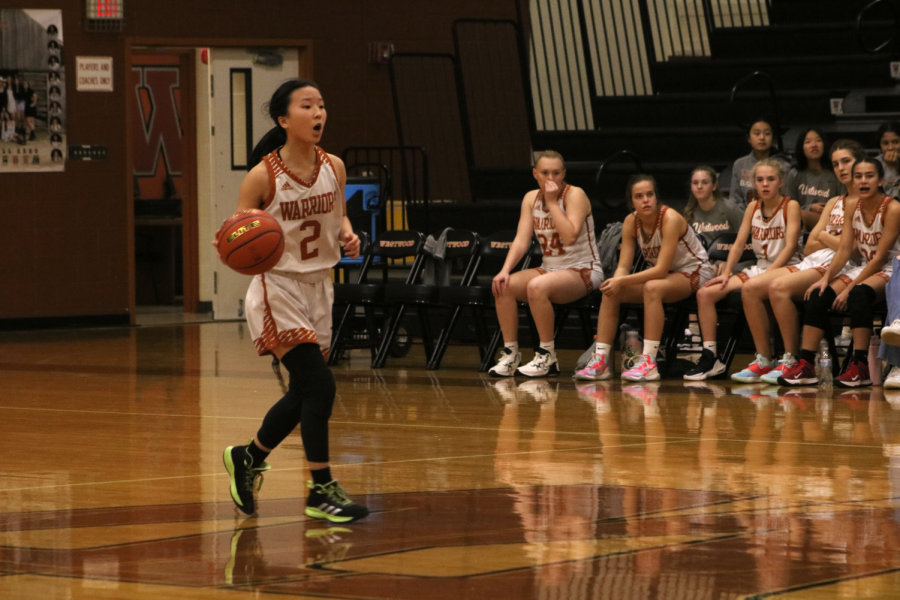 Calling out a play, Claire Lee 26 dribbles down the court. During the game, Lee regularly drove the ball down to the opponents side.