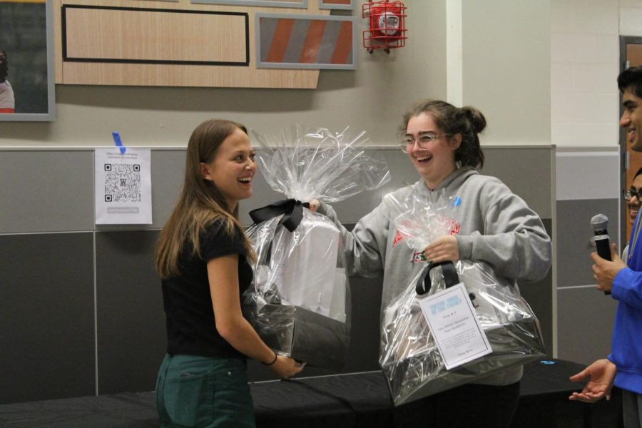 Student Representatives to the Westwood PTA hand out door prizes. Here, Emma Hoskin 23 receives a Winter Essentials prize from Amy Simon 23.