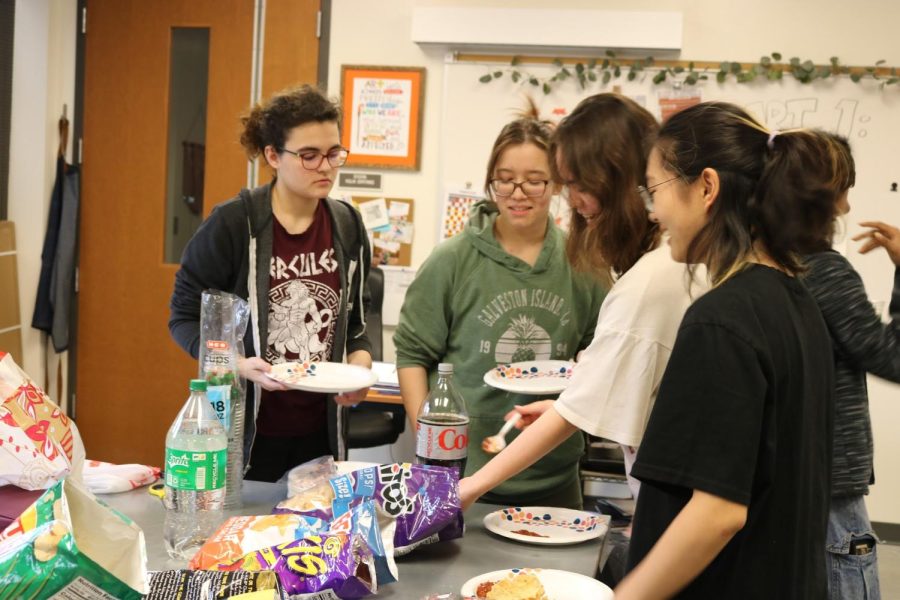 (From left) Juniors Lucy Townsend, Nicole Wang, Alyssa Beekman, and Eli Song fill their plates with food. The juniors enjoyed food and played games.