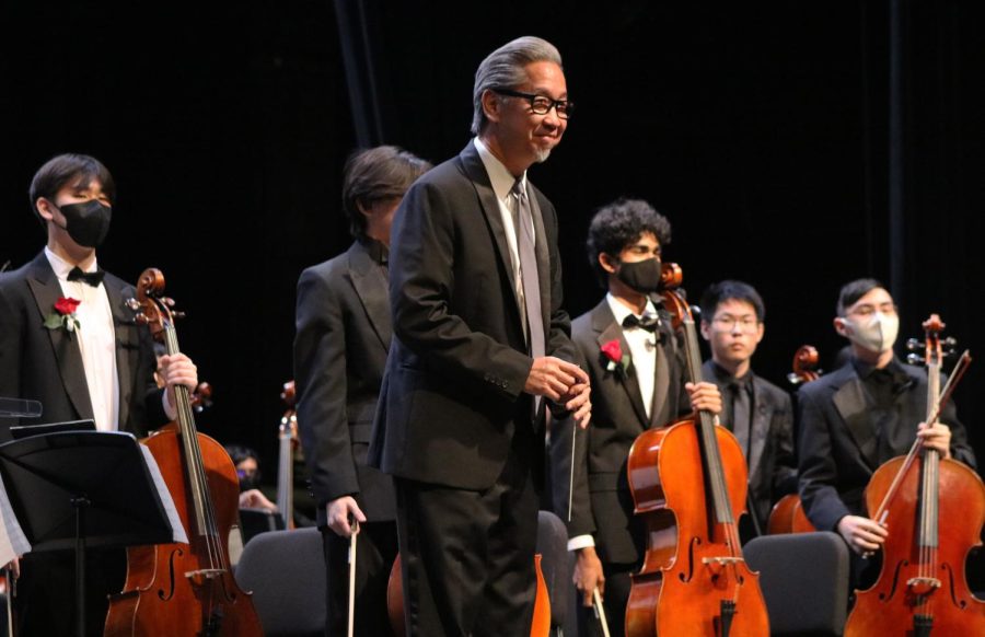 Graciously receiving audience applause, String Orchestra clinician Mr. Bingiee Shiu smiles following the students performance. Shiu, along with the other ensemble conductors, lent their time to rehearse and refine pieces within a short three-day period. 
