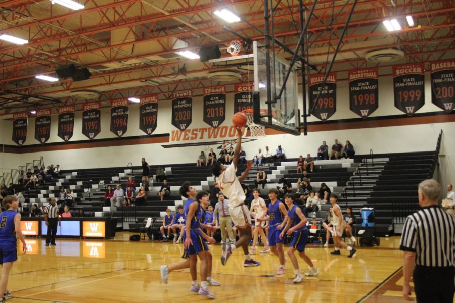 Tyson Woods 25 flies into the air with the ball inches away from the hoop. He came back down after scoring for Westwood. 