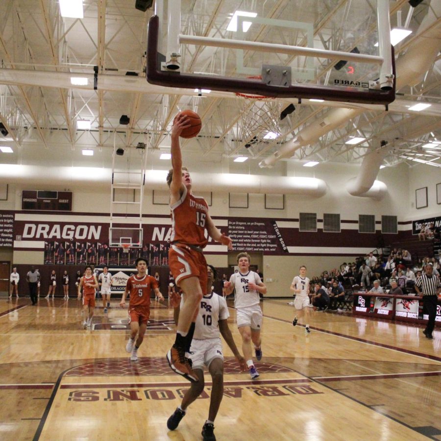 Thomas Burke ‘25 goes up for a layup with Round Rock defense chasing close behind. The Warriors were able to make a fast break and get the ball to Burke to make the layup. 

