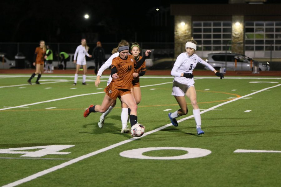 Senior Abigail Burgett kicks the ball down the field to another midfielder. The other defenders around her were there to assist if she needed someone to fall back on. 