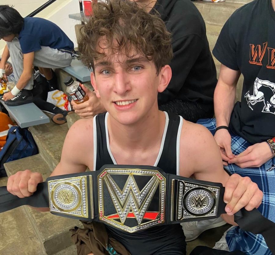 Fred Fisher 24 holds up a championship belt at the district tournament at Vandegrift High School after advancing to regionals.