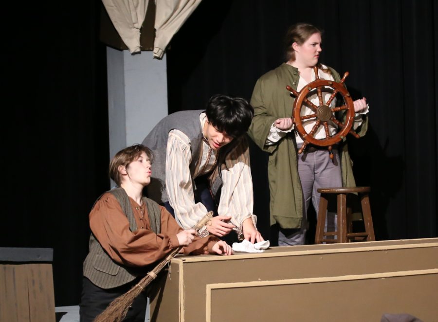 Beneath the wheel of the ship, shipmates Kaya Chen 25 and Cleo Steinhauser 24 discuss daily chores and proceedings. While the shows principal characters followed the narrative, the ensemble cast of pirates and crewmates performed maintenance and silent pantomimes around the ship.