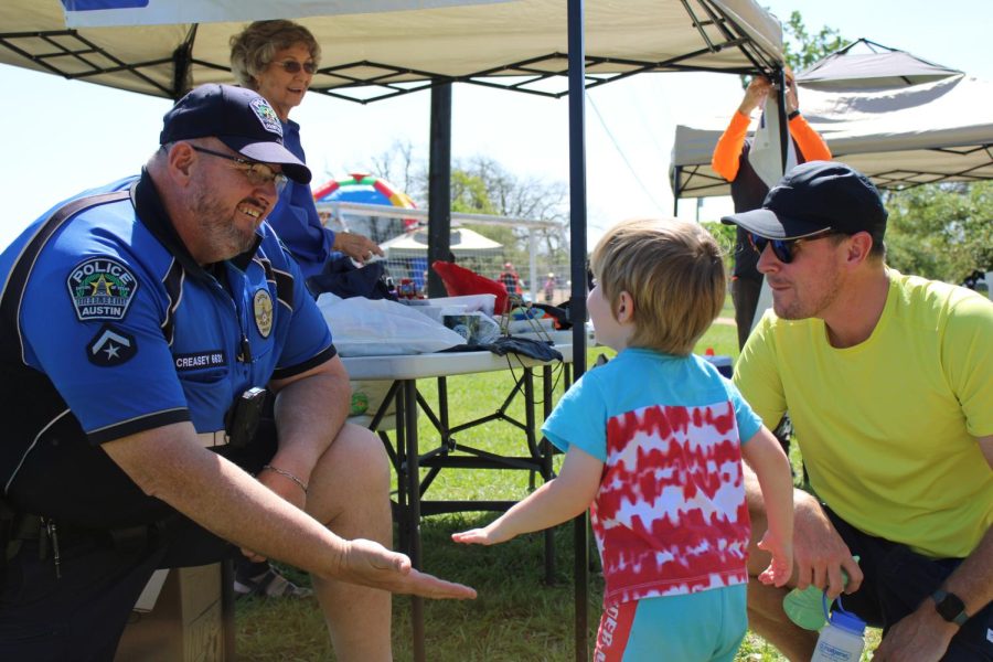 Austin Police Officer Frank Creasey high-fives a child attending the Hanging with Heroes event. Officer Creasey is a District Representative Community Policing Area ADAM 6.