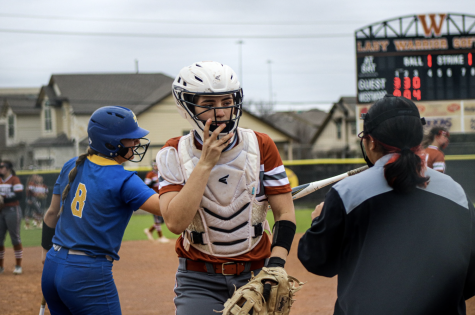Kylie Wardlow 23 readjusts her softball helmet at the end of the inning.