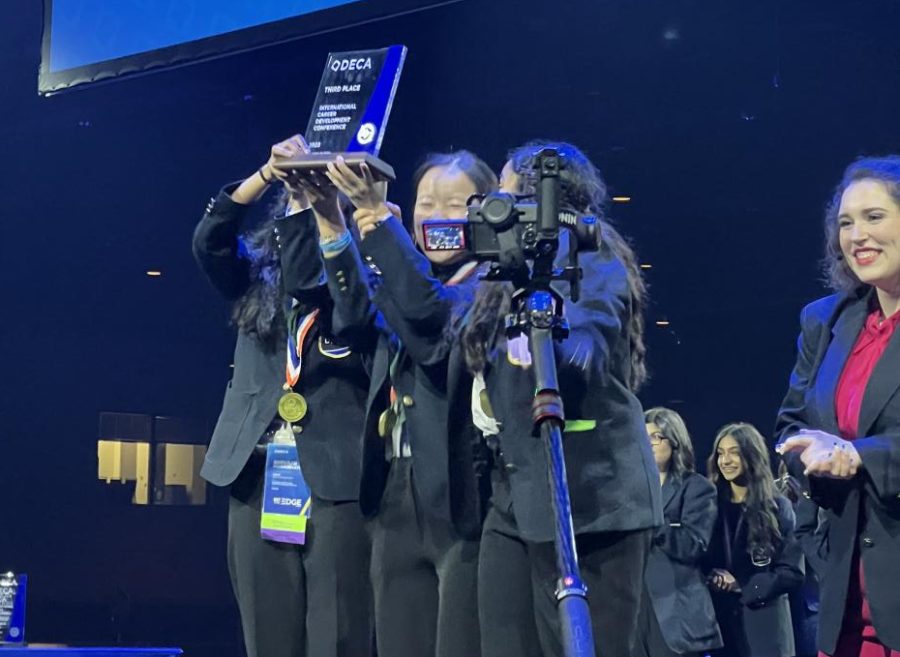 Beaming, Shrishti Mahajan 25, Bailey Zhang 25, and Shivani Kondubhatla 25 hold their 3rd place trophy in the air at the DECA International Conference awards ceremony. The team of sophomores won in the Hospitality and Tourism Operations Research event.