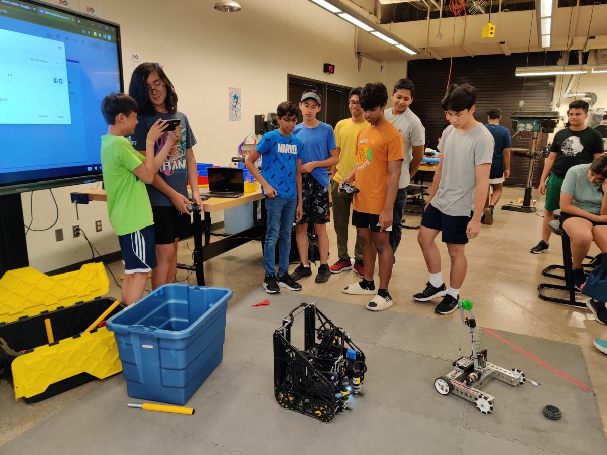 Focused, Archit Garg 26 demonstrates how to drive an advanced FTC robot to the workshop attendees. 