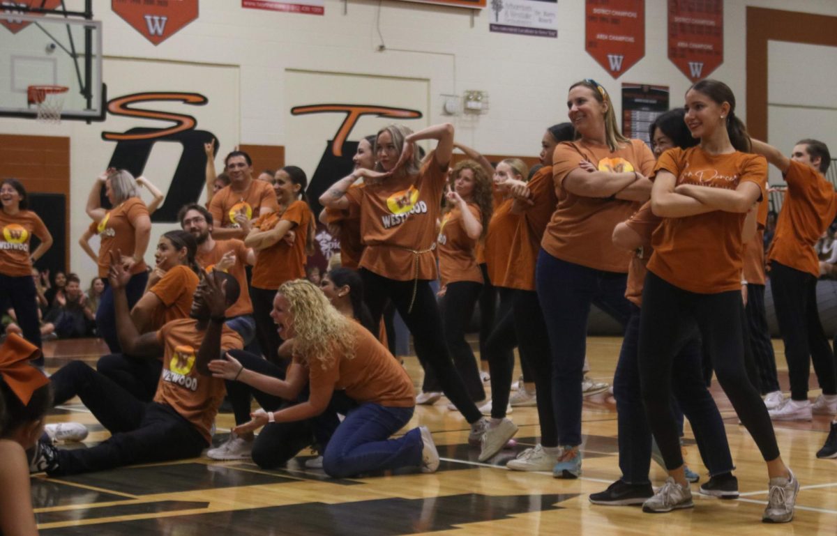 Posing with their SunDancer partners, teachers beam after performing a hip-hop routine. Each SunDancer asked one of their past or current teachers to dance with them during the pep rally, choreographing many partner moves in the routine to create a fun and uplifting performance. 