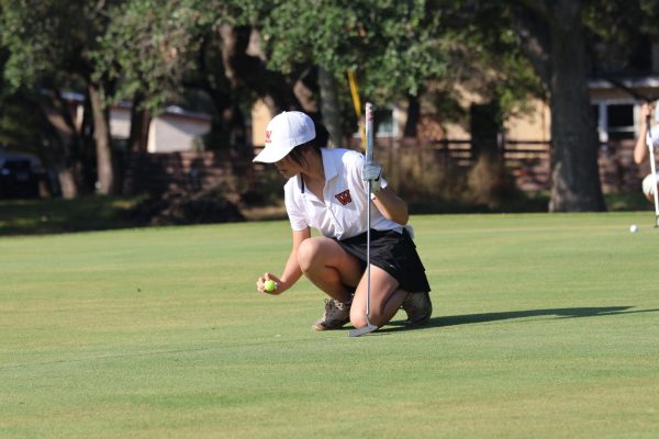 Crouching down, Marlene Luo 25 carefully aims her ball towards the hole. Luos team, the Westwood Girls 2nd team, started out on the 8th hole, with Luo hitting a birdie on the 1st. It was very fun spending time with our teammates and working together to get a good score, Luo said.