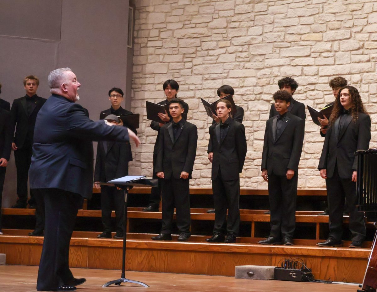 Bellator, the tenor base choir, stands tall as they sing on stage. Choir Director Andre Clark strums along on a guitar adding a uniqueness to the song. Students from Chamber performed alongside the new members of the choir program. 
