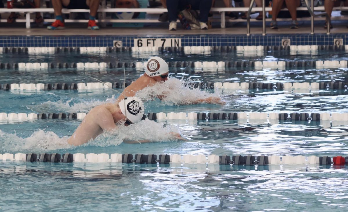 Beating back a McNeil swimmer, Liam Lewis 26 finishes his 50 yard breastroke leg in the 200 yard Medley Relay. 