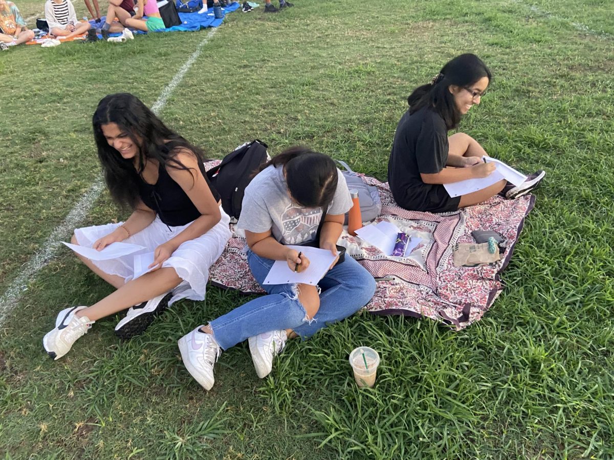 Annika Anand 24, Sritanvee Alluri 24, and Anannya Sathaye 24 write letters to their future selves at Senior Sunrise. At the event, students hung out with friends while watching the sunrise, eating snacks, and writing their letters. I liked the idea that you write little letters for yourself and then you get it back at the end of the year, Sritanvee Alluri 24 said. 