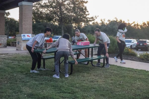 Clocking in at 7 a.m., Benjamin Li 25 and Andrew Zhang 25 work with the Central Texas SPCA staff to arrange tables for booths at the event. Barktoberfest had various booths such as ones for small businesses, vets, and a kids play zone.