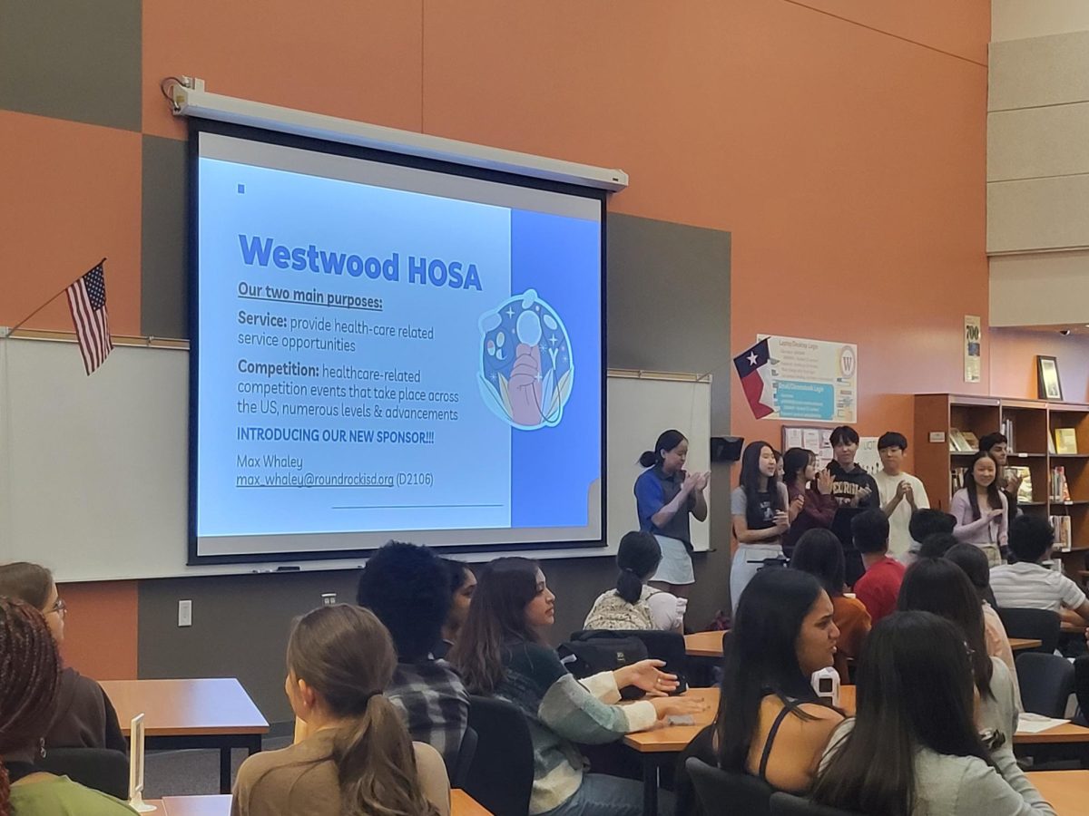 Presenting a powerpoint to members in the Great Room, HOSA officers introduce the clubs main purpose and new club sponsor. The first meeting of the year had been postponed for two months during the search for a sponsor.