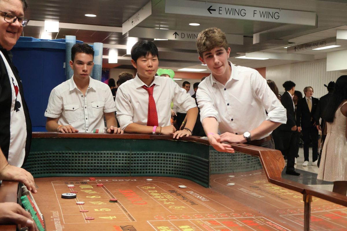 Playing casino games, Ryan Lee 25 and Coleman Loyd 25 enjoy their time at the Homecoming dance. Pacesetters brought casino tables to the atrium to offer a diverse selection of activities for students to participate in at the dance.