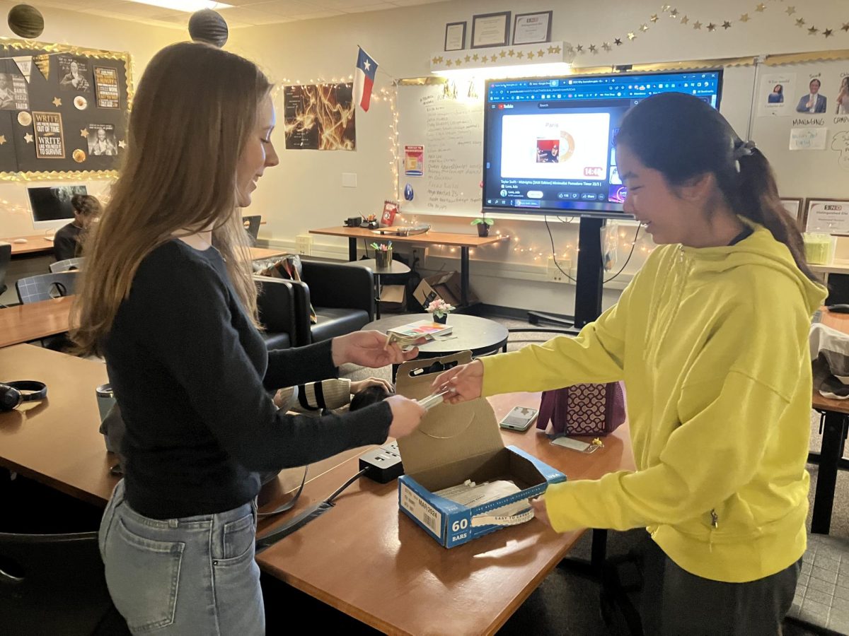 Hannah McDonough 24 buys a Worlds Finest Chocolate bar from Tian Tianwen Gao 27. DECA club members started selling Worlds Finest Chocolate bars in September to fundraise for their clubs.