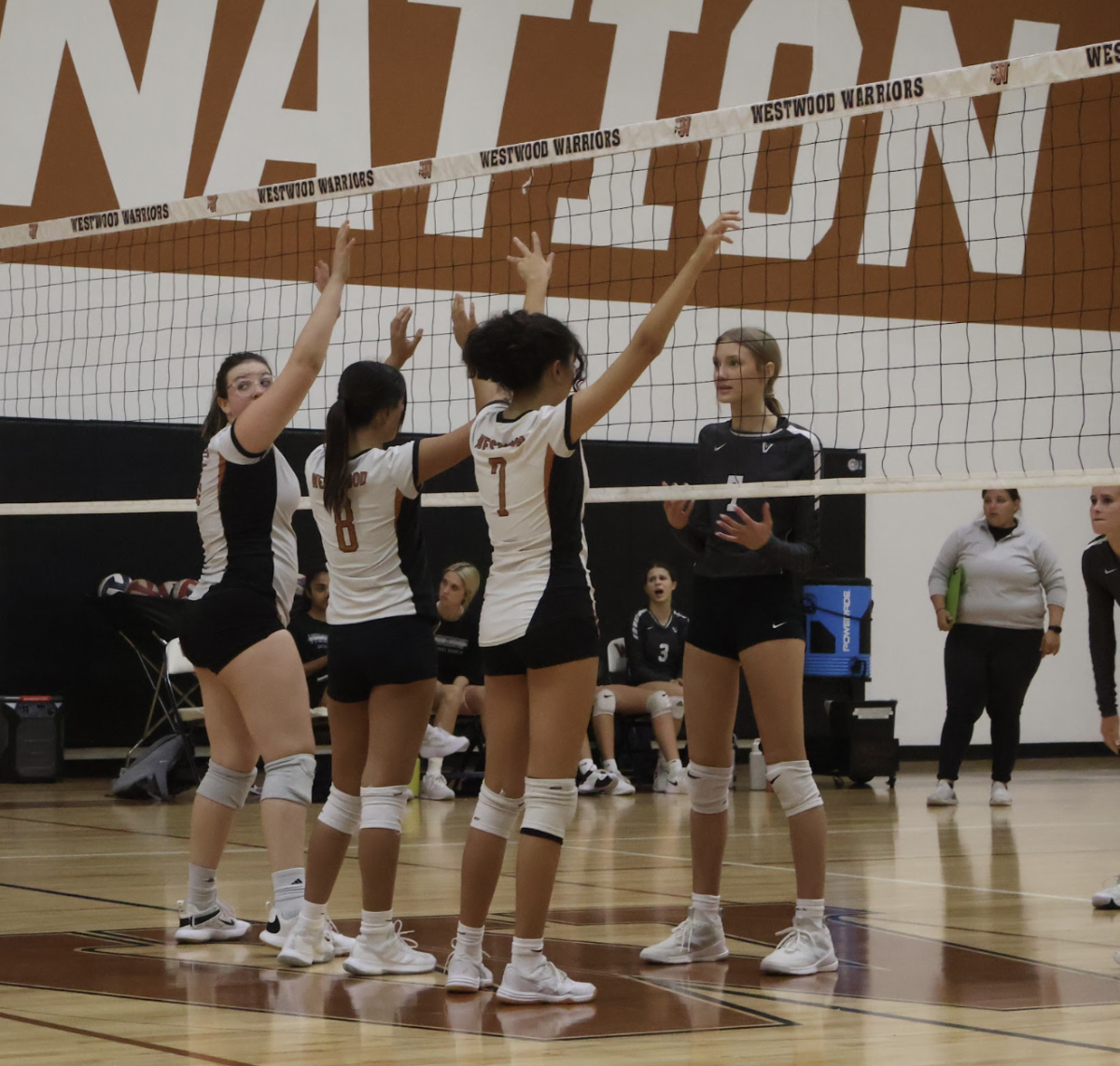 Freshman DeLaney Selfridge, Gabriela Hernandez, and Alexa Hinojosa stand in position to block the ball from the opposing hitter. The Warrior defensive prowess led to a stellar 25-19 victory in the first set.