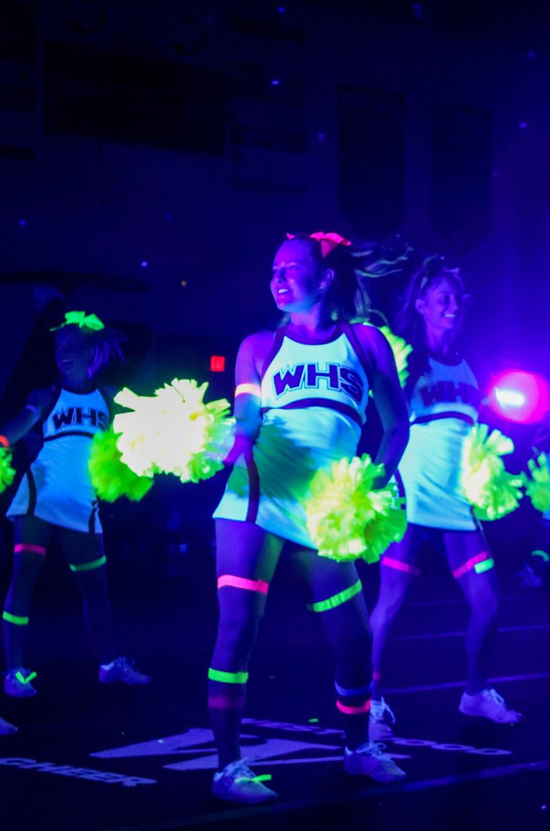 Decorated with glowing neon tape, Zoe Meredith 26 performs with the cheerleaders as a show of school spirit. The cheerleaders impressed the audience with their lifts and stunts as the opening performance to the pep rally. 