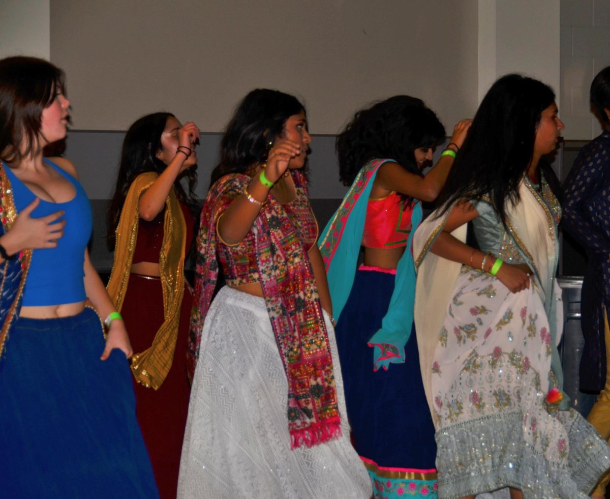 In a circle, students dance to Bollywood music while following a routine. Other South Asian organizations performed and led attendees in the dance as well. 