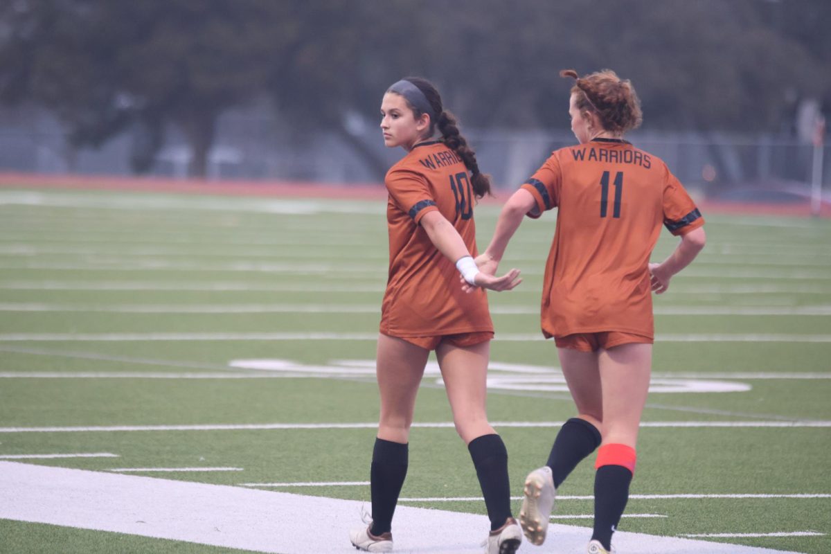 As the run back to their positions on the field, Jaelynn Solis 27 and Henley Patak 27 share a celebratory clap. Soils and Patak played pivotal roles in the Warriors blowout win.