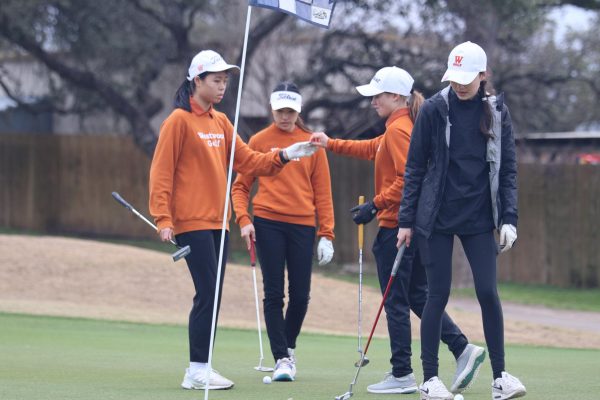 Collaborating, the Westwood Girls 1st team assesses their results from their current hole. Each Westwood team consisted of three or four players, who provided each other with support and encouragement throughout the tournament. Playing with my teammates [was the highlight], Nancy Lu 27 said.