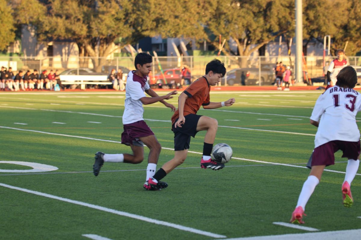 Running with the ball up the field, Aiden Shen 26 shields it from a defender. A key player in this game, Shen scored both goals for the team. 