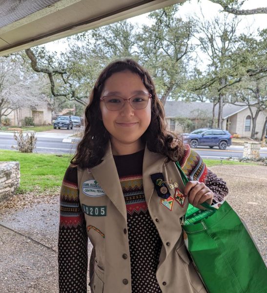 Smiling, eighth grader Lia Ham sells Girl Scout cookies to a neighborhood family. Since 2016, Girl Scout cookie prices have risen by $3.