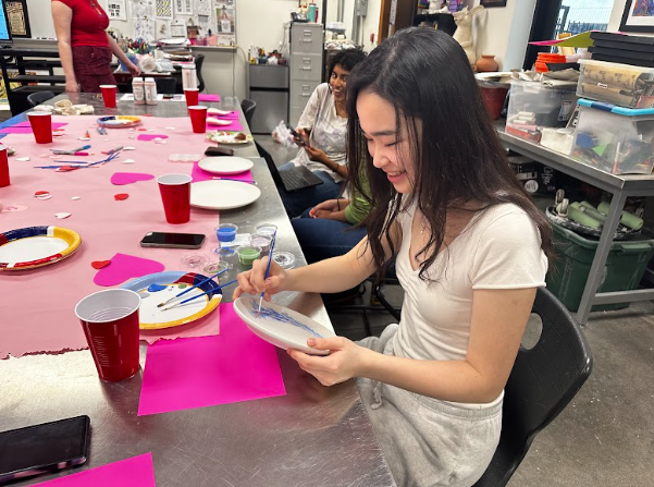 Paintbrush in hand, Jennifer Rong ‘25 creates a flower design on a plate. Wrong created multiple pieces at the event. “I wanted to come to the fundraiser because it’s a really fun club and it’s a really good way to destress after a long week,” Rong said. 