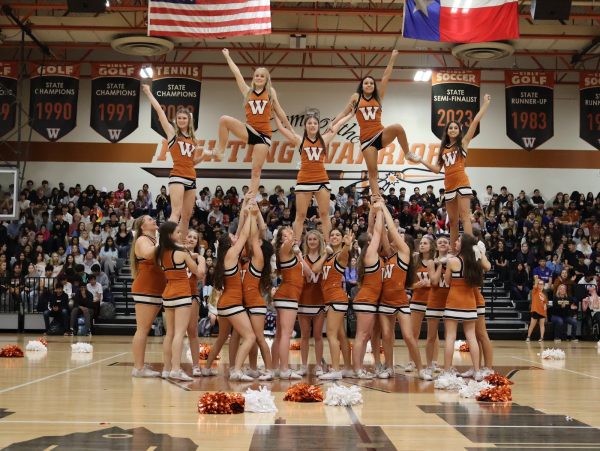 Forming a pyramid formation, the Cheer team conclude their performance. Some members held the sko wood symbol, amplifying school spirit. 