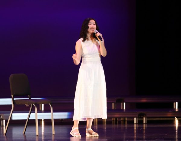 On the PAC stage, Kalia Wang 26 performs a verse from her duet with Ryan Gu 26. The duo performed Both Sides Now by Joni Mitchell, and the Playlist performance marked their third year in a row performing duets at end-of-year concerts.