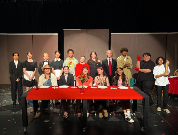 Seated for supper, the cast of Cafe Murder poses for a picture. Half of the show was based on improvised answers to audience questions, meaning the show changed every night. 