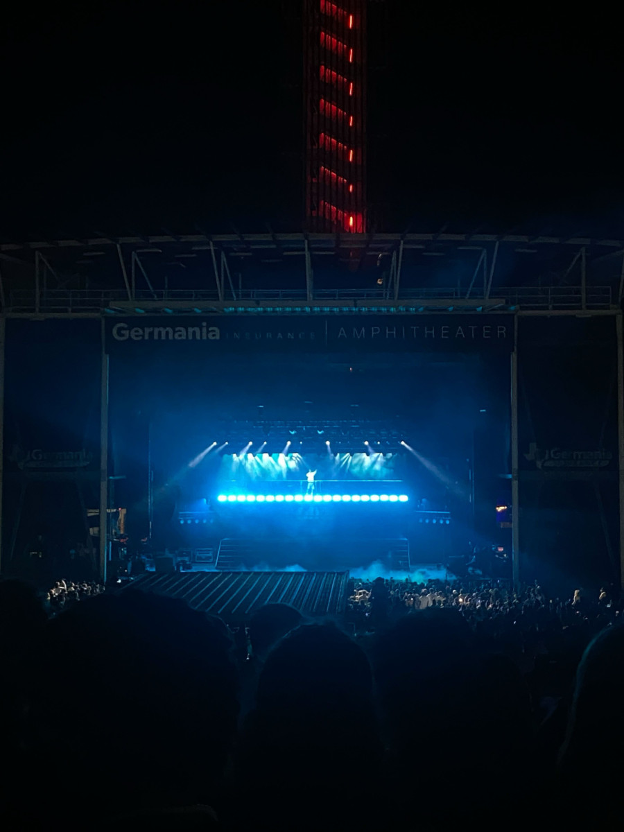 At the Germania Amphitheatre, blue lights illuminate the stage where 21 Savage performed. Through his energetic rap style and electrifying stage presence, 21 Savage brought a lively and fun performance to Austin.