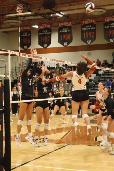 Preparing to hit an incoming ball, Chloe Paddock '25 blocks the volleyball from the opposing team during the second set. After the warriors lost the first set, they brought their spirits back. Despite fighting hard, the warriors lost the set 23-25.