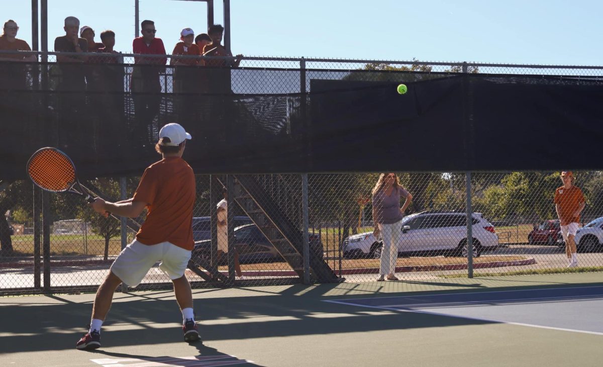 With his mom nervously watching, Elliot Fearnow '26 returns a serve in his tiebreaker point. After a long rally, Fearnow was eventually bested by his opponent. "I've played [my opponent] before," Fearnow said, "so I would've liked to win. [I need to improve] my mental game and consistency."