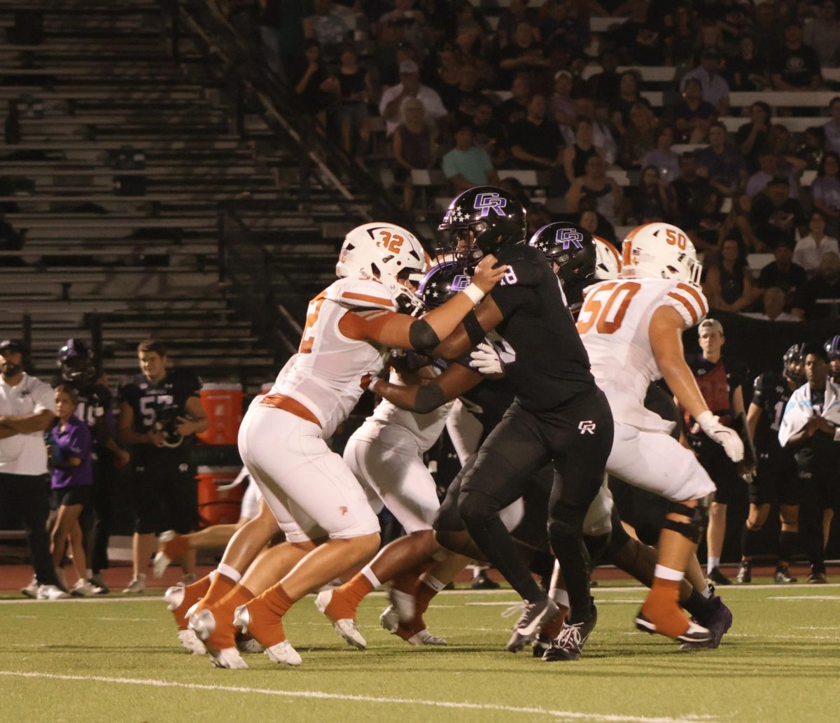 Clearing the way for his running back, Cam Greene '27 blocks a Cedar Ridge cornerback to allow the running back to speed by for the first down on Friday, Sept. 21. After this scoring drive, the Warriors went into over time where they ended up losing 35-28 in the final moments of the game. "We were ready for an over time game" Coach Anthony Wood said. "All we have to do is execute on the ball better"