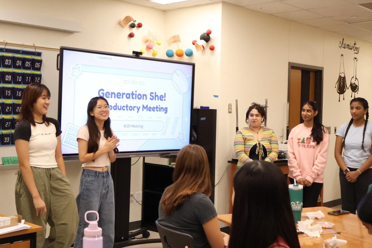 Standing at the forefront of the room, GenShe Vice President Natalie Ju '26, President Josephine Sun '26, Secrectary and StuCo Rep Ariana Fresques '26, Director of Operations Samhita Nagarakanti '26, and Director of Marketing Samymy Gorapalli '25 (from left) present an informational slideshow about GenShe. GenShe officers presented a general club overview while members made inspirational bracelets.