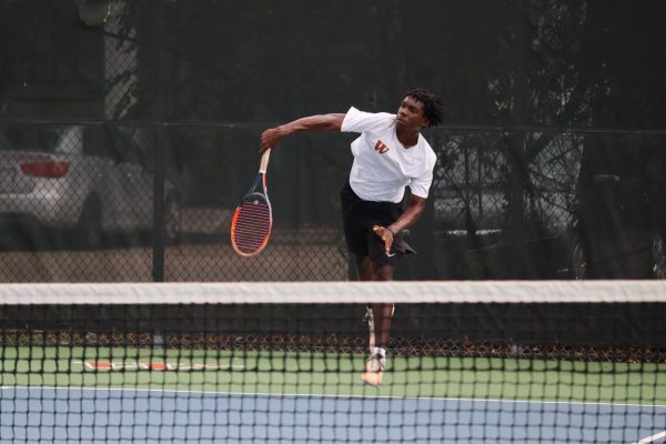 Jumping up, DeAndre Weeks '25 hits the ball with an overhead serve. Weeks matched up with Jiya Guleria '28 for the mixed doubles division, finishing with a score of 10-5.