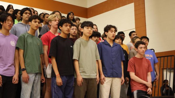 In the corner of the Field House gym, seniors Loy Bhowmick, Minsung Kim, Jonathan Simon, Zachary Petiprin, and fellow choir singers perform the alma mater before a volleyball game. The performance marked the conclusion of Choir Camp, uniting all choirs for the song.